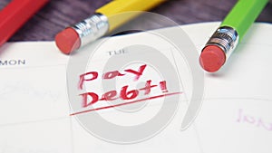 Close up of pay debt word on calendar