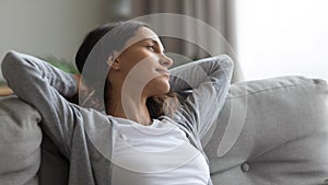 Close up peaceful woman resting on couch, looking to aside