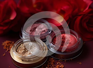 A close-up of pearlescent shimmery red,pink and orange glitter eyeshadows for creating eye makeup