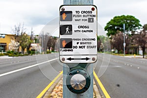 Close up. Pedestrian crosswalk button and instructions in the middle of the empty urban street