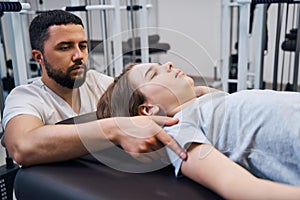 Close up pediatric physiotherapist treats young girl on rehabilitation decompression machines