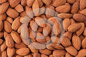 Close up peeled almonds nuts background top view using for your advertising.