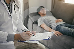 Close up of pen doctor writing with came to visit the patient at home while he was suffering from stomach ulcers and noted the tre photo