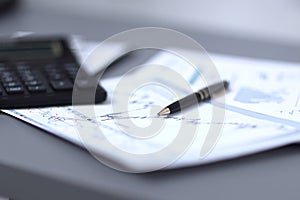 Close up.pen, financial chart and calculator on the businessman`s Desk