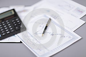 Close up.pen, financial chart and calculator on the desktop