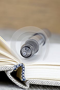 A close up of a pen lying on an open journal diary notebook