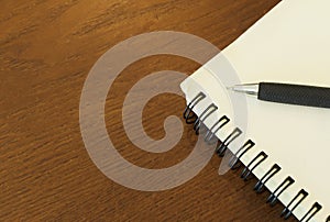 Close up of Pen with notebook blank page on wood table backgrounds