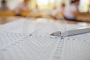 Close-up pen on optical form of standardized test with answers b