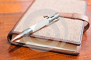 Close-up of pen on top of agenda or notebook
