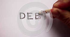 Close-up Of Pencil Eraser Erasing Debt Word photo