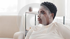 Close-up pensive female face with dark skin in profile. Portrait young adult african american ethnic black woman