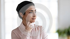 Close up of pensive indian female look in distance thinking