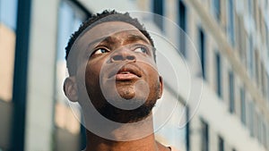 Close up pensive thinking ethnic man looking around outdoor business student guy look up on urban building think