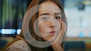 Close-up of a pensive young woman indoors with a reflective mood. Contemplative indoor portrait with blurred background