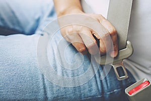 Close Up of people man hand fastening seat safety belt in car