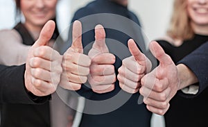 Close-up Of People`s Hand Showing Thumb Up Sign Against