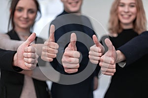 Close-up Of People`s Hand Showing Thumb Up Sign Against