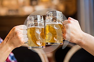 Close-up of people toasts with beer in pub.