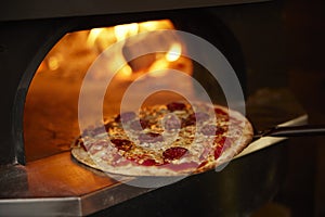 Close Up Of Pepperoni Pizza Being Baked In Wood Fired Oven
