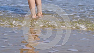 Close up of a person bare feet walking at a beautiful tropical beach.