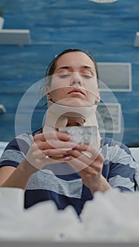 Close up of person with cervical neck collar looking at capsule tablets