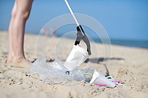 Close Up Of Person Collecting Plastic Waste From Polluted Beach