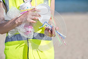 Close Up Of Person Collecting Plastic Waste From Polluted Beach