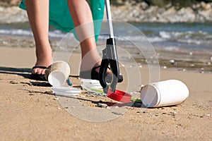 Close Up Of Person Collecting Plastic Waste From Polluted Beach Using Litter Picker