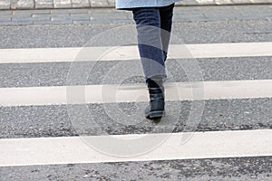 Close-up of person crosses a pedestrian crossing back view