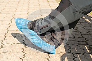 Close-up of person feet wearing shoe-covers for protection