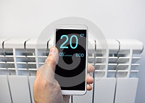 Adjusting temperature on thermostat with smartphone photo