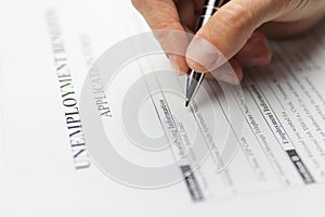 Close-up of a person hand filing social security benefits application form. Concept of Covid-19 coronavirus and stay at home