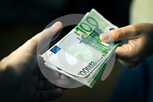 Close-up Of Person Hand Giving Money To Other Hand. Transfer of Euro Banknotes
