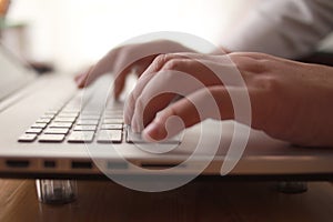 Close up of person hand typing on laptop keyboard, author writing on pc computer, businessman programmer working
