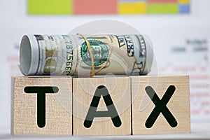 Close-up Of Person Hand Using Calculator With Tax Word On Wooden Blocks