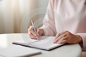 Close up of a person hands writing down notes with a pen.