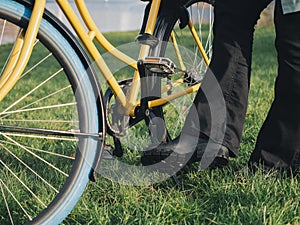 Close-up of Person Lifting Kickstand on Yellow Bicycle