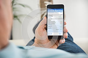 Close-up Of Person With Mobile Phone Doing Online Banking