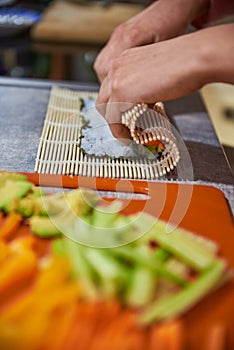 Close up of a person preparing japanese food. Close up of a person making sushi rolls. Close up of a person preparing sushi