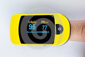 A close up person`s finger using a pulse oximetry, noninvasive method for monitoring people`s oxygen saturation