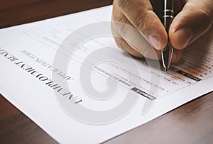 Close-up of a person`s hand filing social security benefits application form.  Concept of coronavirus and stay at home order