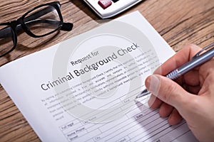 Person Filling Criminal Background Check Form