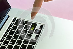 Close up person`s hand finger pushing the `text` text on a button of laptop keyboard isolated concept f