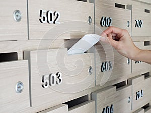 Close-up of person`s hand . hand removing a letter from mailbox in the entrance hall of an apartment building