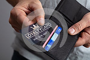Person Removing Loyalty Card From Wallet photo