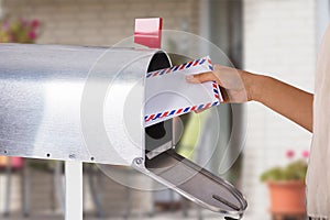 Person Removing Letter From Mailbox photo