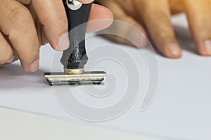 Close-up Of Person`s Hand Stamping On Approved Application Form or Notary public in office stamping documents for signing approva