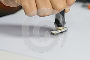 Close-up Of Person`s Hand Stamping On Approved Application Form or Notary public in office stamping documents for signing approva