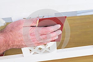 Close-up of person sanding piece of wooden furniture