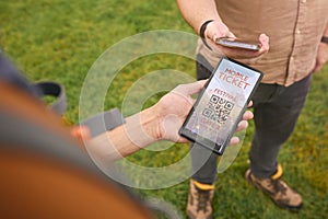 Close Up Of Person Showing E Ticket On Mobile Phone At Entrance To Outdoor Concert